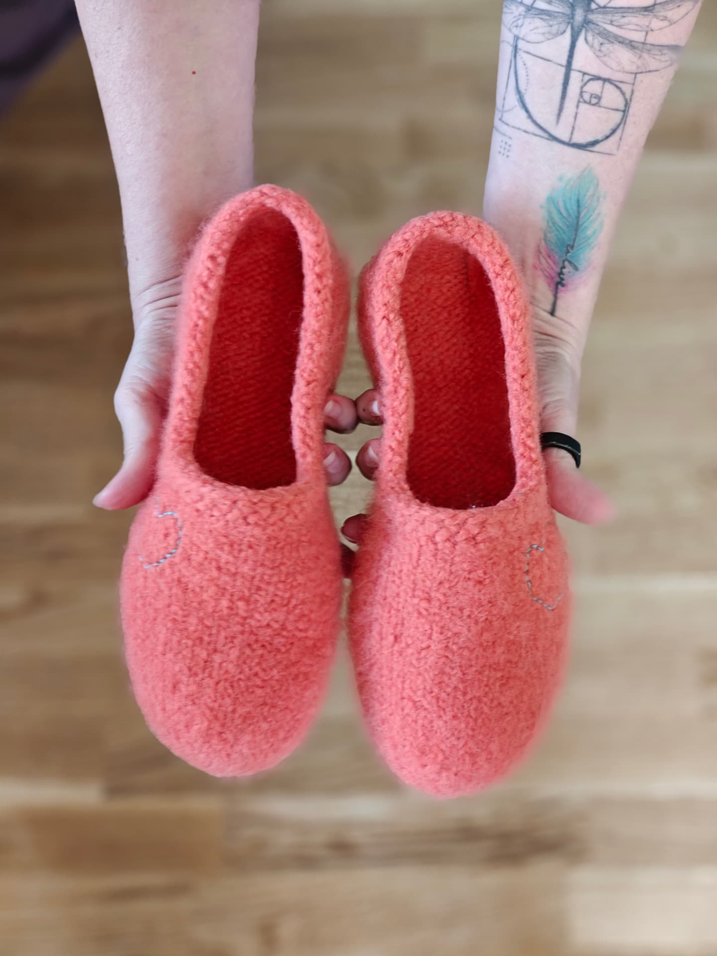 Hand-knitted coral pink wool slippers with an embroidered heart