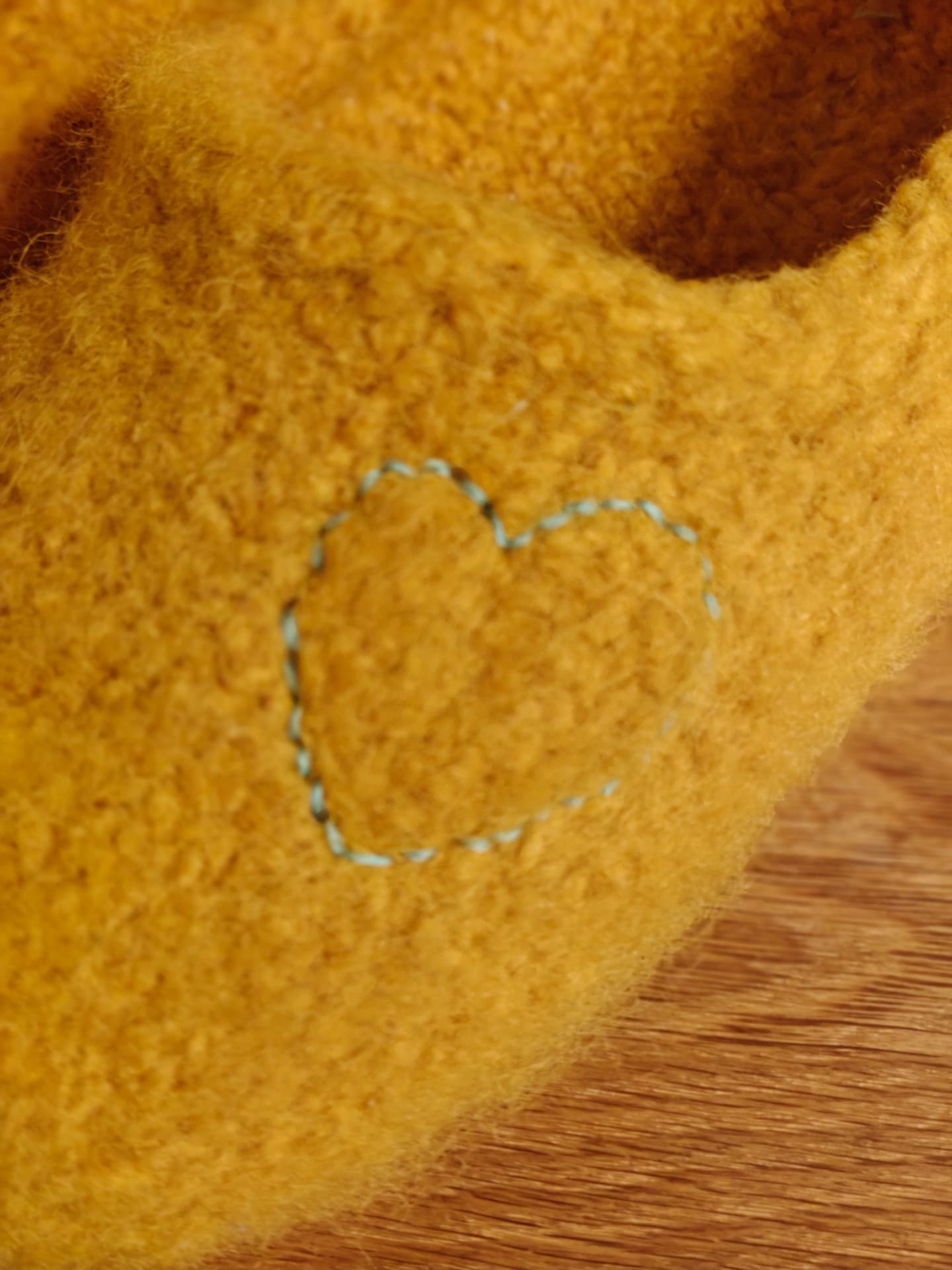 Embroidered heart on a yellow slipper, close-up