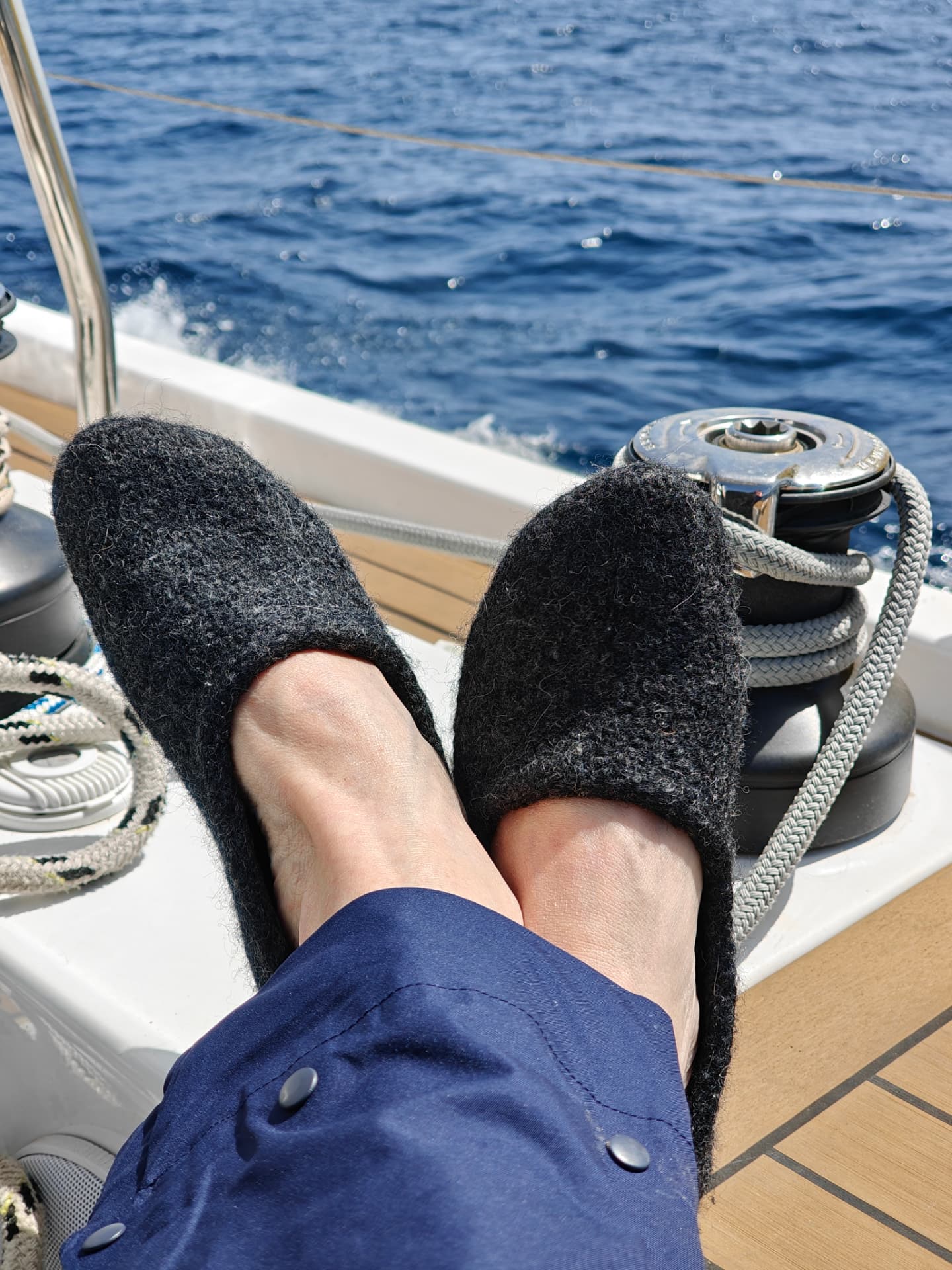 Dark grey slippers worn on a sailboat