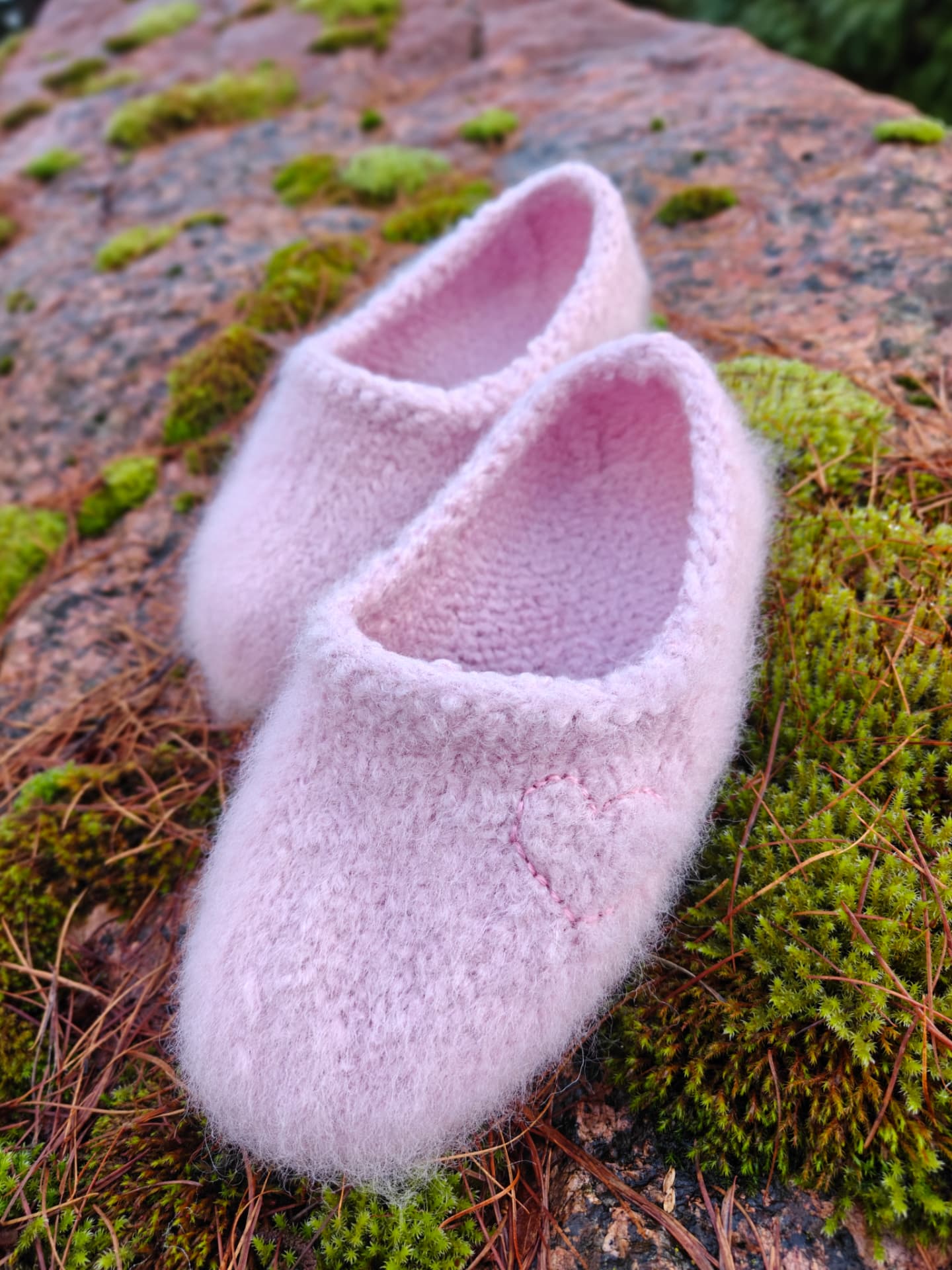 Pink slippers with an embroidered heart on moss