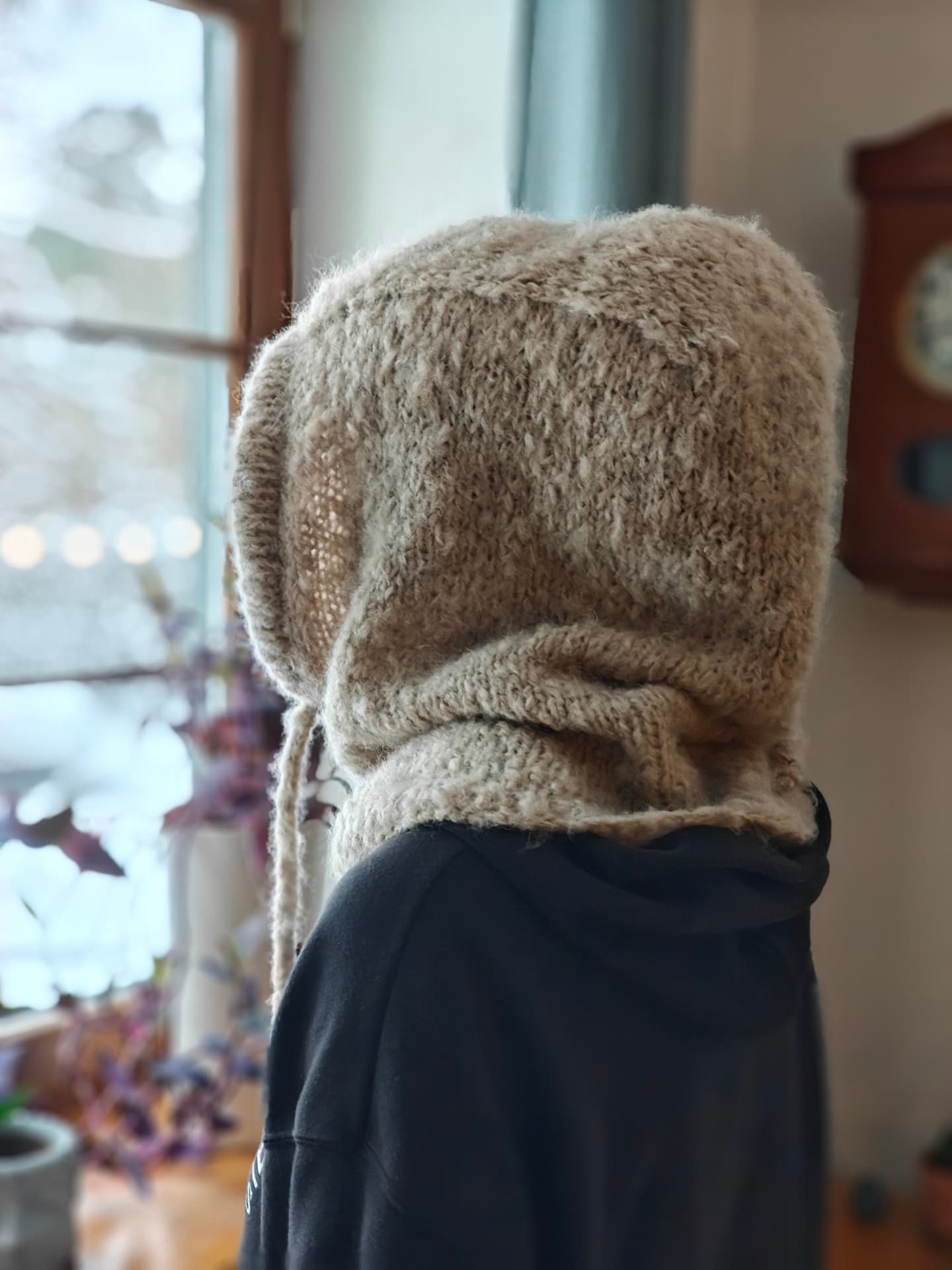 Knitted balaclava worn by a window