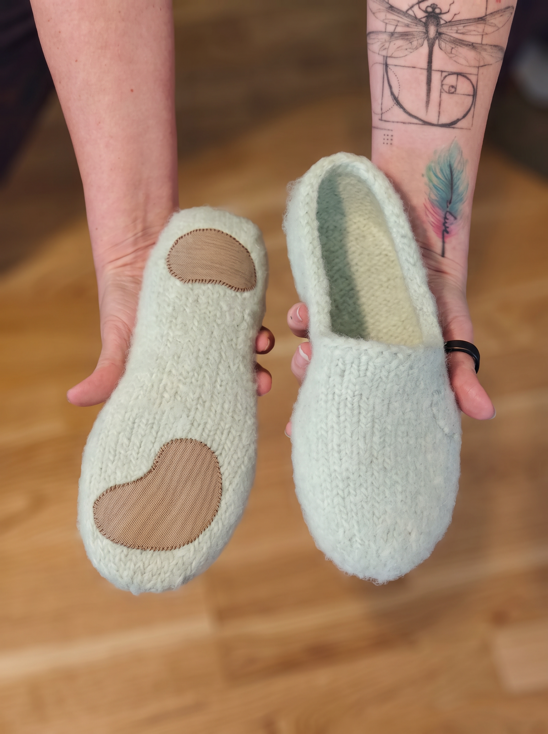 Hand-knitted moss green wool slippers with an embroidered heart